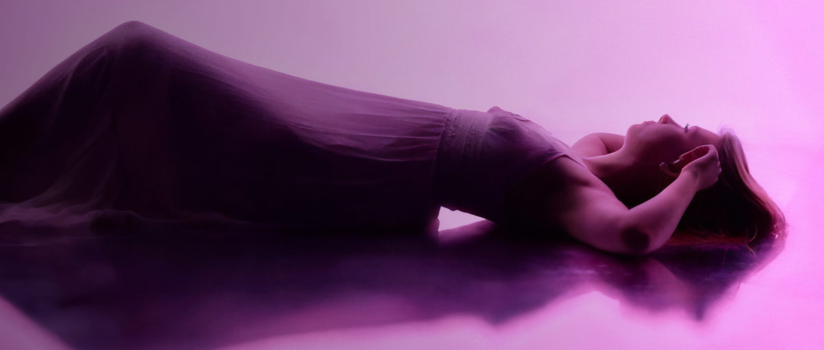 Flowing silhouette rests under luminous purple tones, creating a calm and immersive atmosphere.